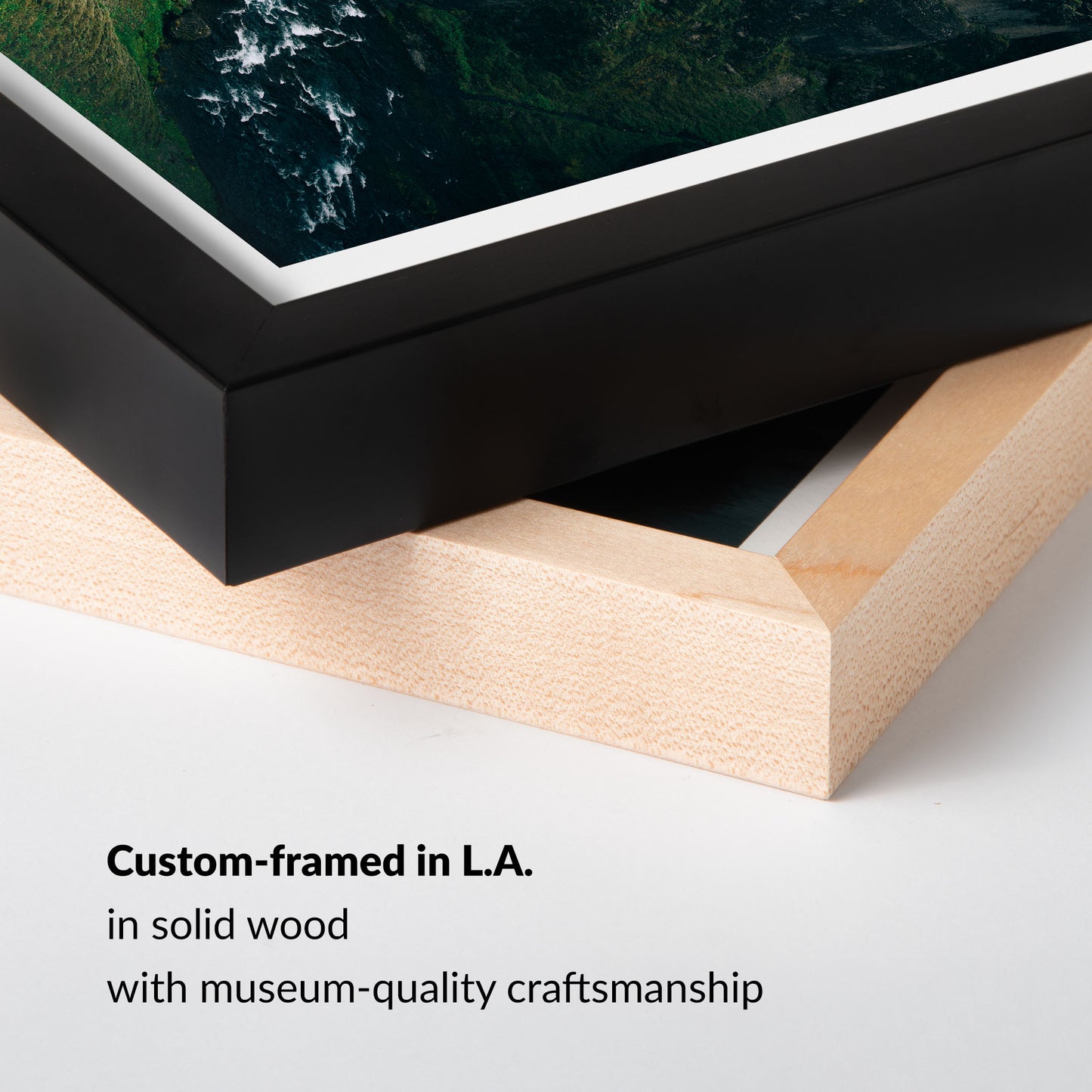 Close-up of a framed artwork with a black frame and wooden base on a white background.