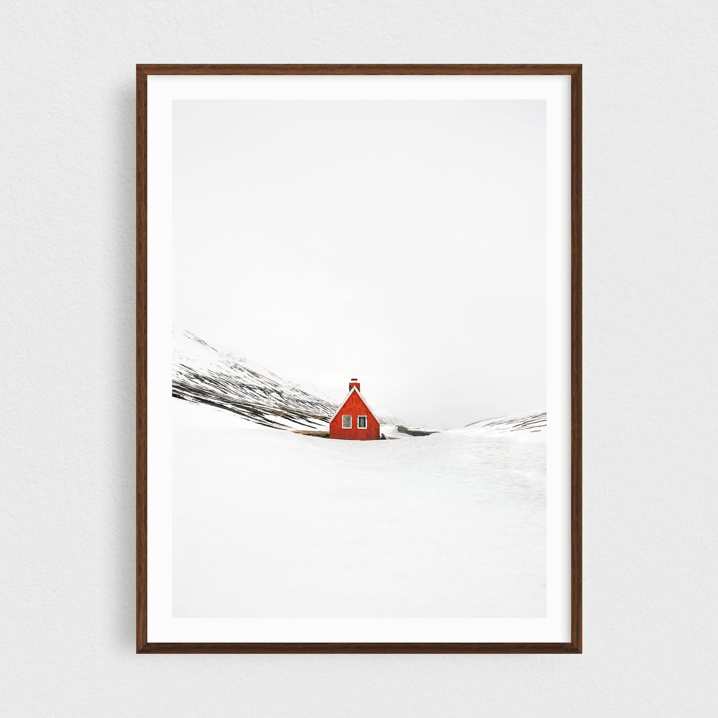 Iceland fine art photography print featuring a red cabin in winter, in a walnut frame