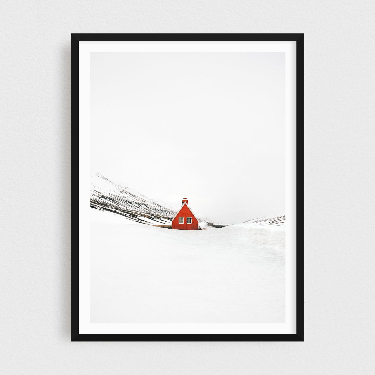 Iceland fine art photography print featuring a red cabin in winter, in a black frame