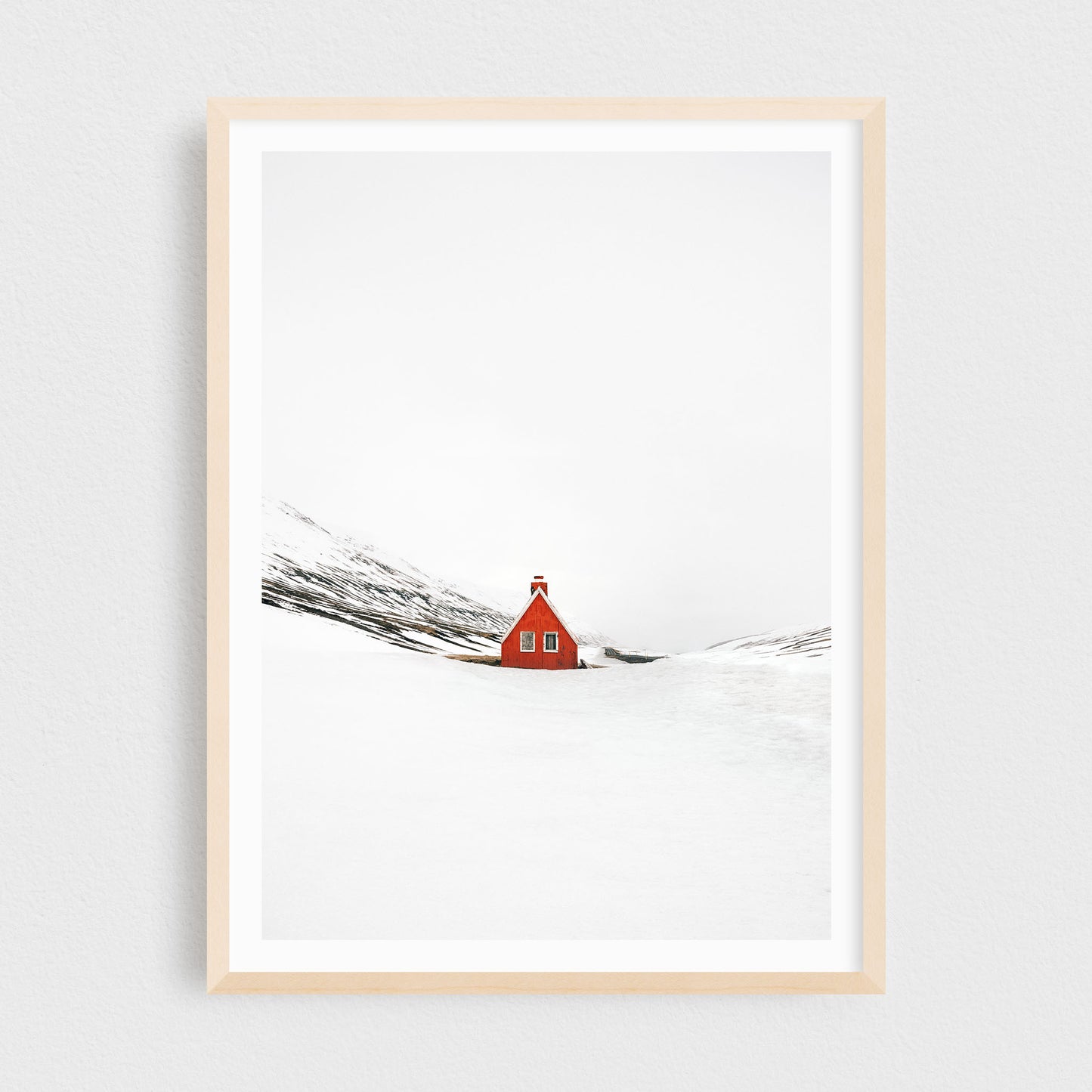 Iceland fine art photography print featuring a red cabin in winter, in a maple frame