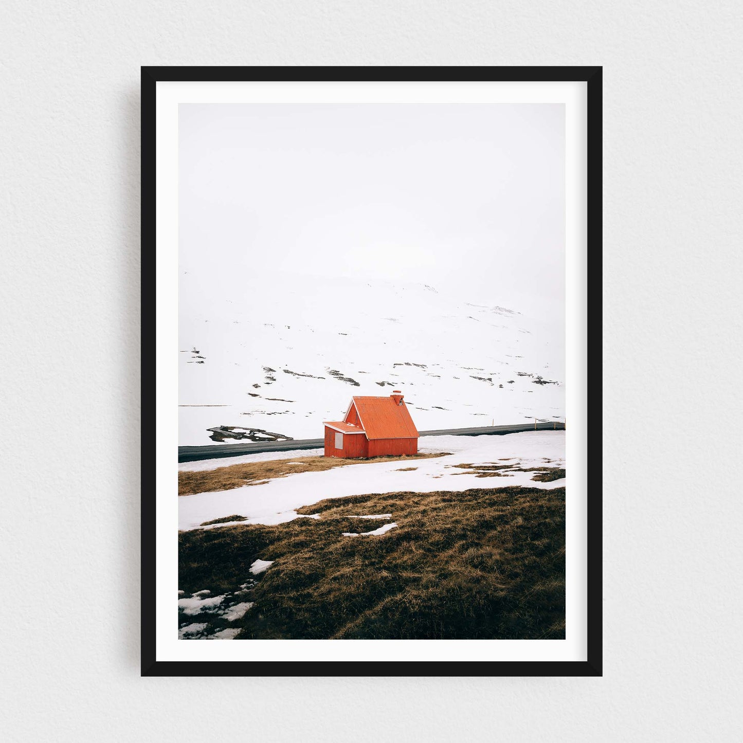 Iceland fine art photography print featuring a red cabin in winter, in a black frame