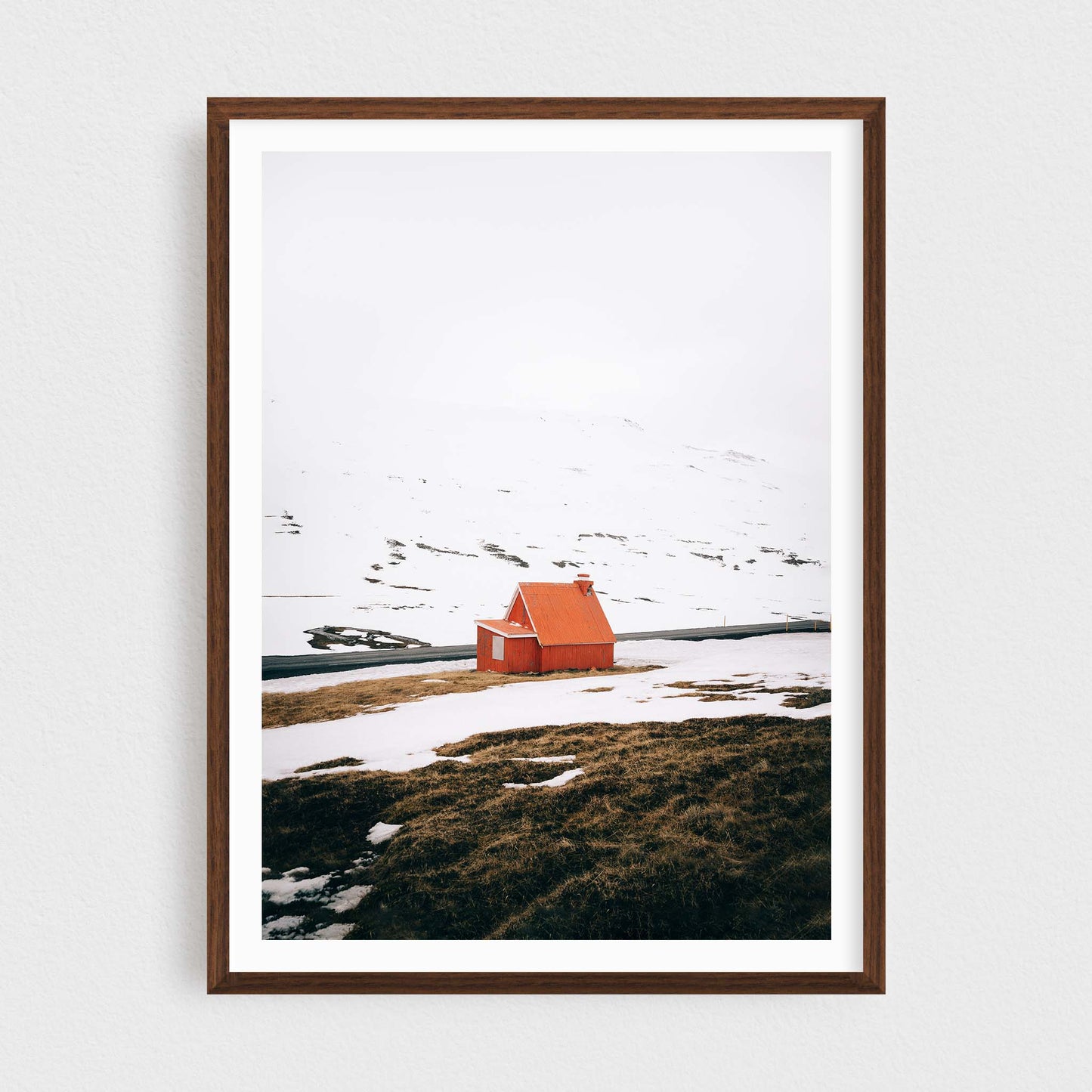 Iceland fine art photography print featuring a red cabin in winter, in a walnut frame