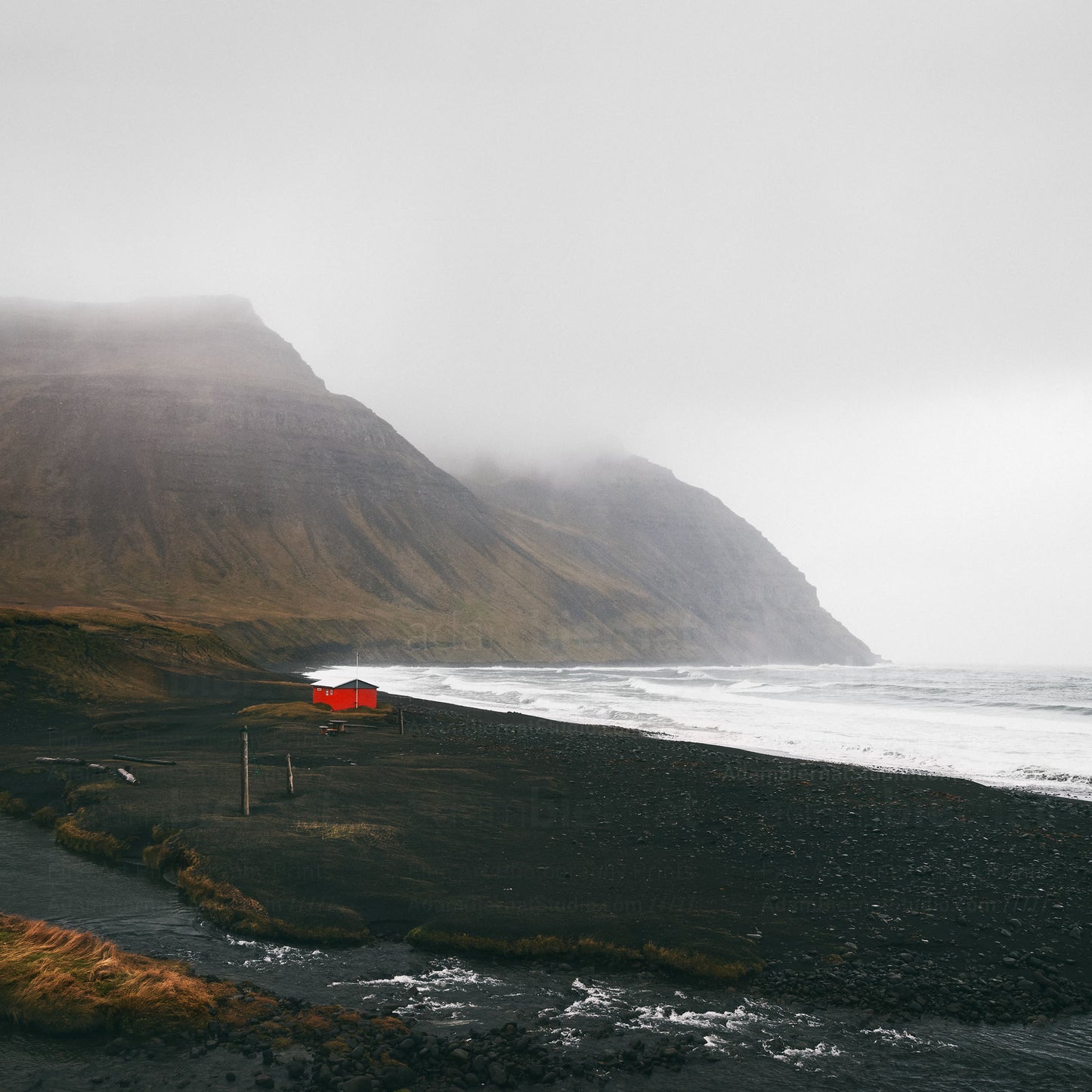 Red cabin on a black sand beach photography print featuring Westfjords in Iceland